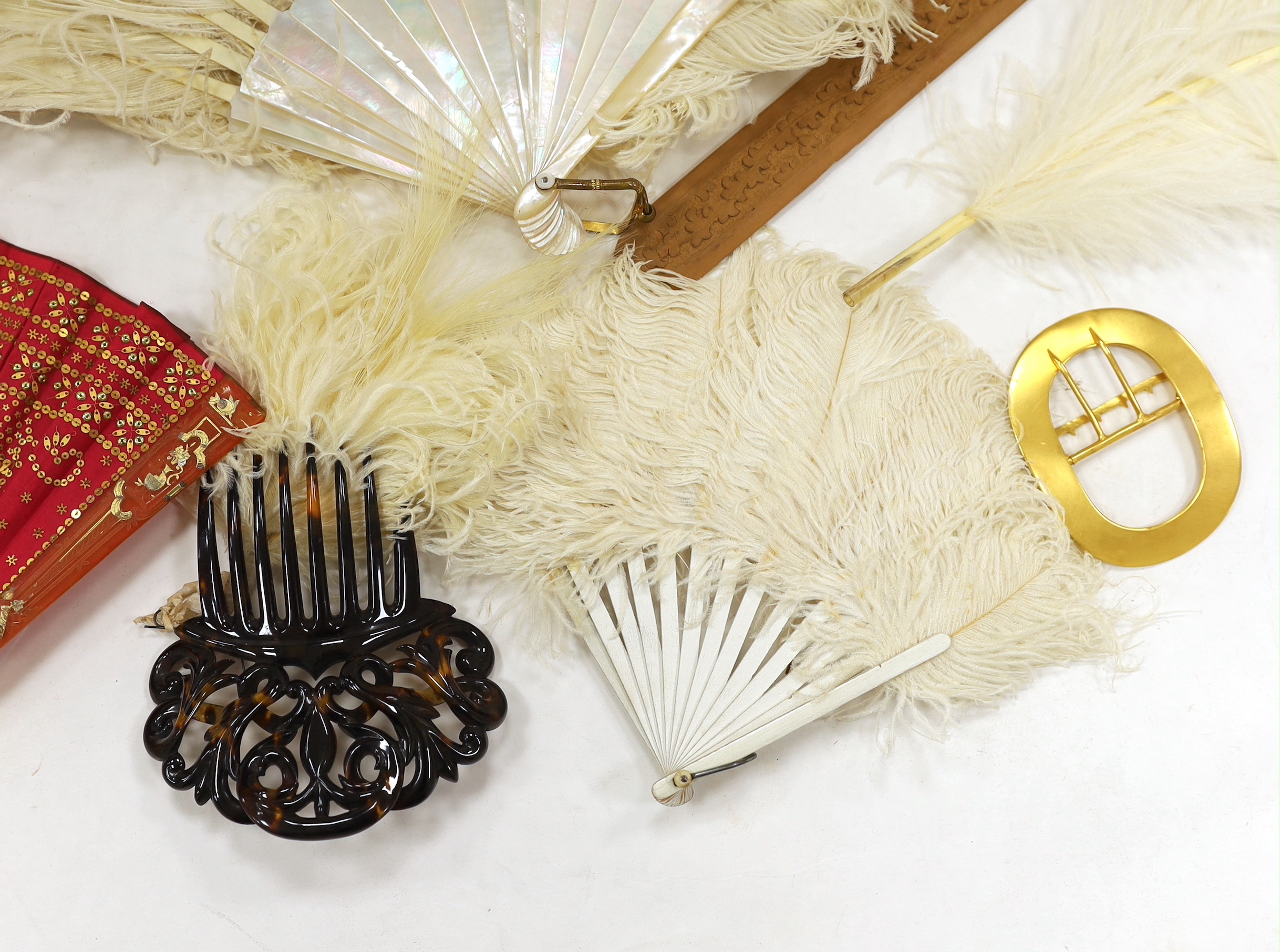 A Regency sequin and horn fan, a bone brise fan, a large white feather fan and a similar miniature fan and hat ornament two hair combs, etc